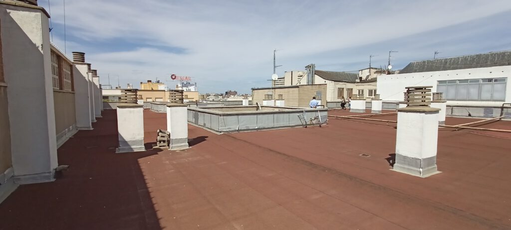 Azotea en ciudad con sumideros y cielo despejado.
