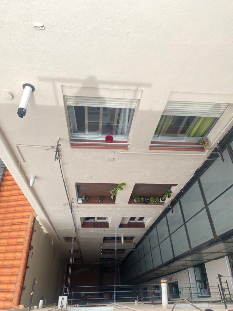 Edificio con ventanas y plantas en el balcón.