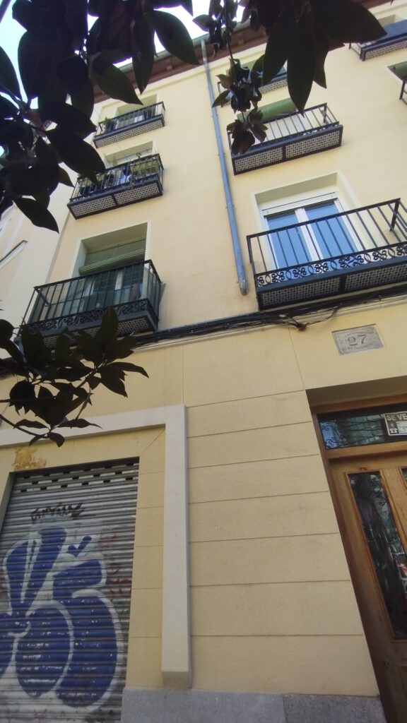 Edificio con balcones y persiana grafiteada en Madrid
