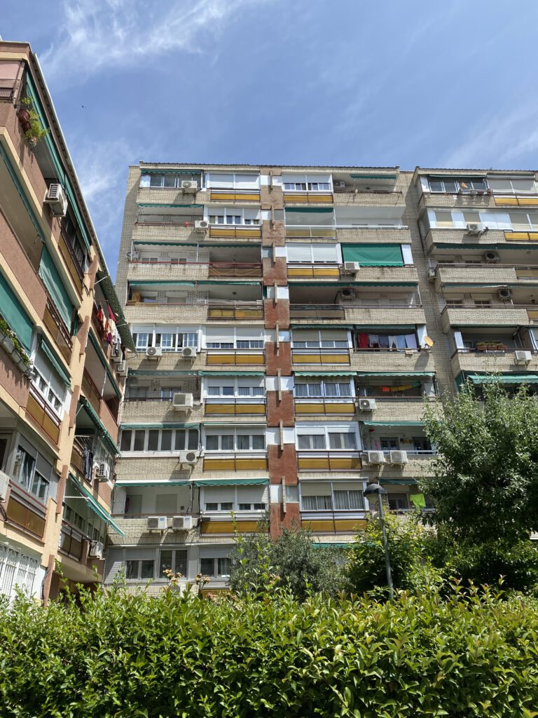 Edificio de apartamentos con cielo azul y vegetación