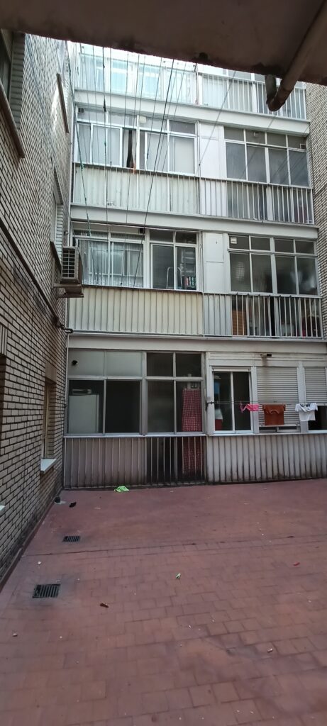 Patio interior con ropa colgada en tendederos.