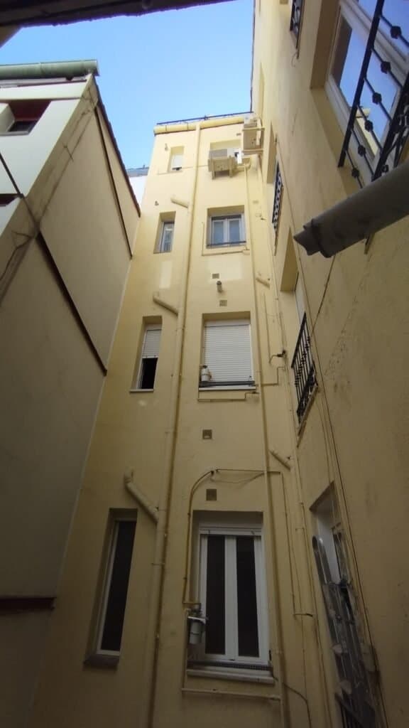 Patio interior de edificio con ventanas y tuberías