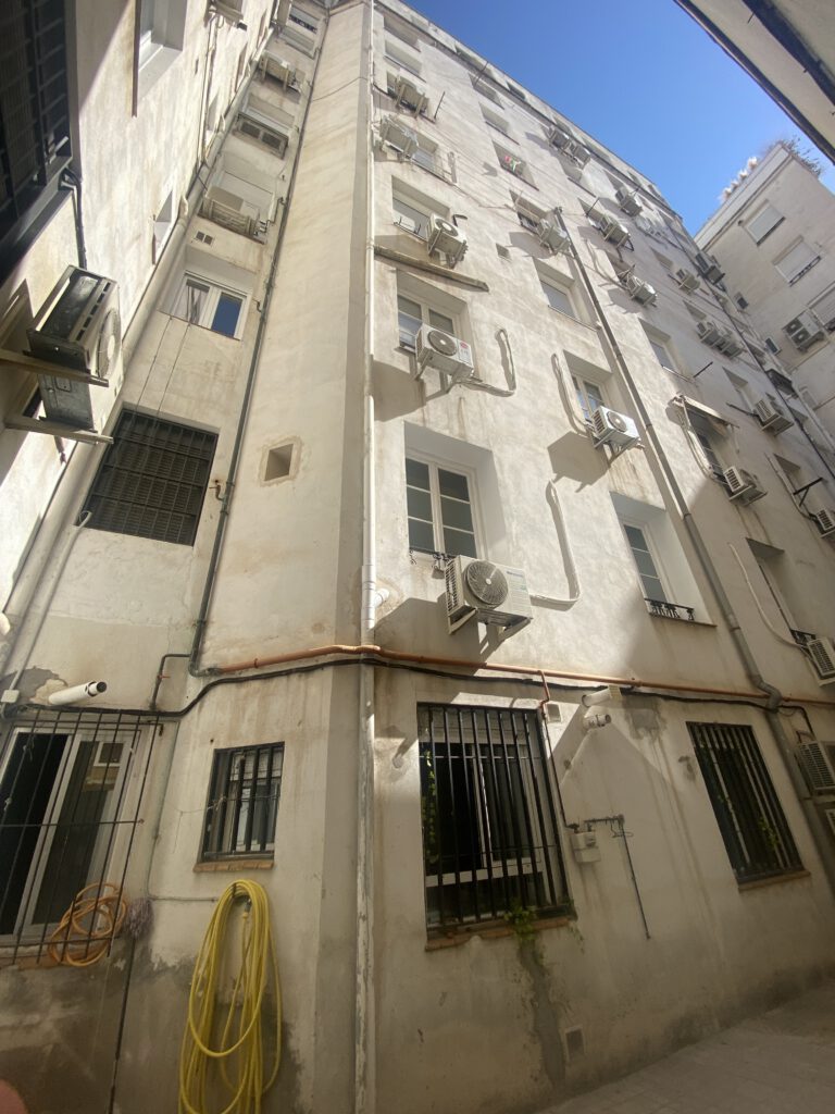 Edificio con aires acondicionados y cables exteriores.