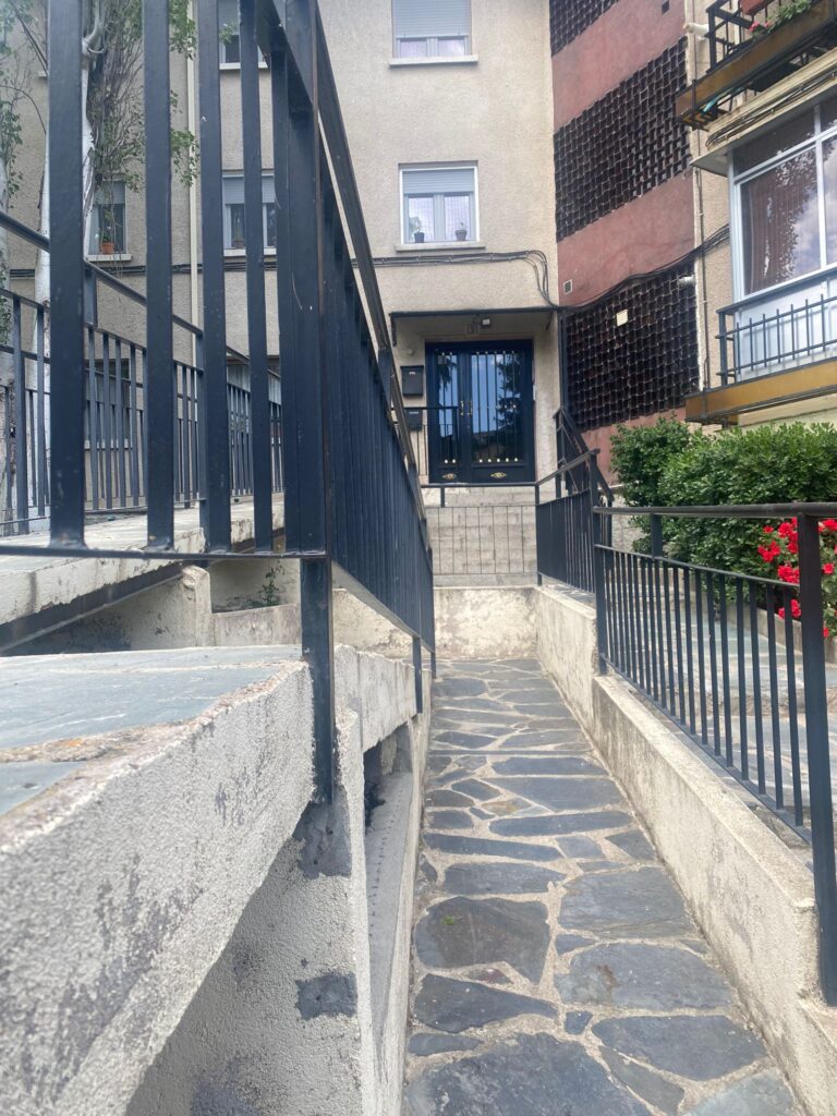 Entrada con rampa accesible a un edificio residencial.